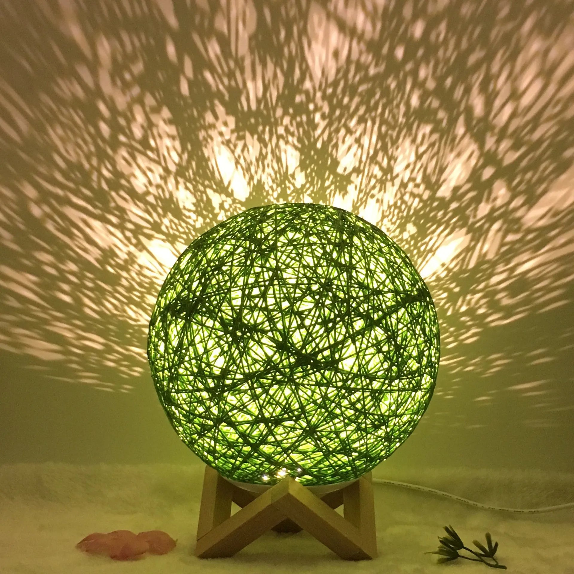 Rattan ball table lamp with woven shade and warm LED lighting on wooden surface