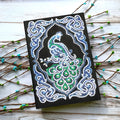 Peacock Beauty A5 diamond painting journal with black cover, shaped and bright drills, showing 142x207mm dimensions.