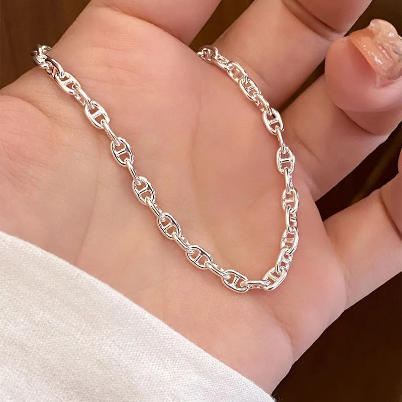 Minority stackable bracelet in polished 925 sterling silver pig nose chain style on white background