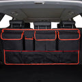 Car trunk hanging storage shopping bag in black with red piping, showing Oxford cloth construction and reinforced handle