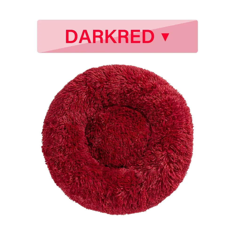 Fluffy donut-shaped pet bed in long plush fabric, shown in a light grey colour with a raised edge.