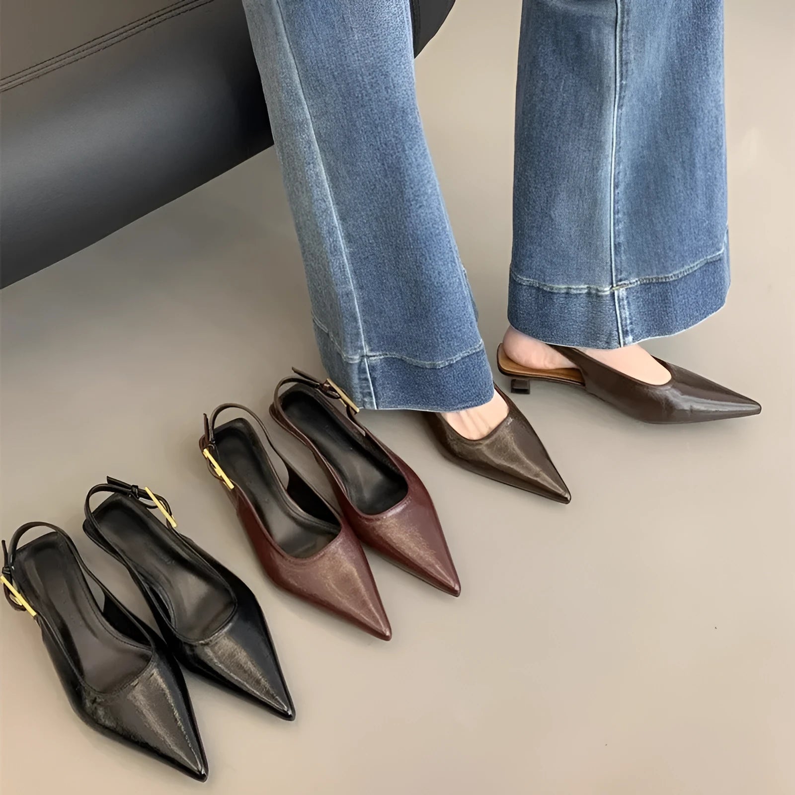 Women's black pointed toe low heel shoes with an ankle strap and rubber sole.