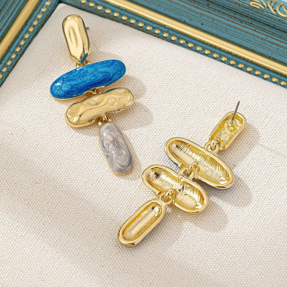 A pair of women's geometric stud earrings with a multicolour electroplated finish on a zinc alloy base.