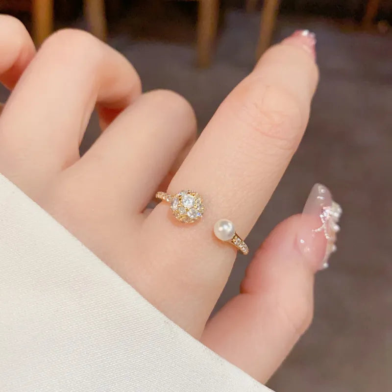 Gold or silver plated open-end pearl ring with round zircon stone on copper base.