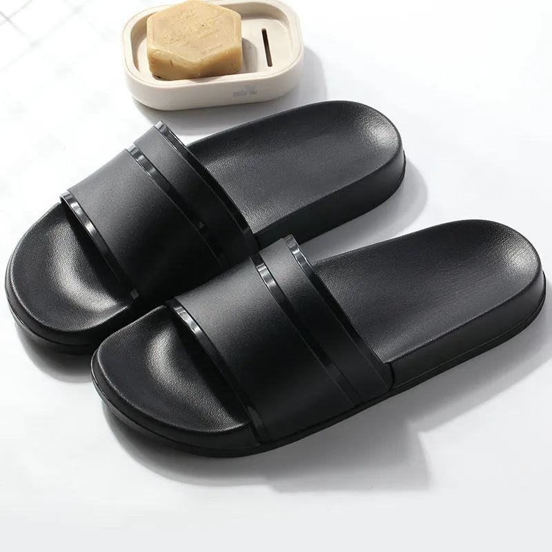 Unisex non-slip bathroom slippers in non-woven fabric with thick sole, available in black or white, sizes S to XXL