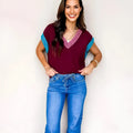 Burgundy loose-fitting V-neck sweater with short cuffed sleeves and contrast trim detail