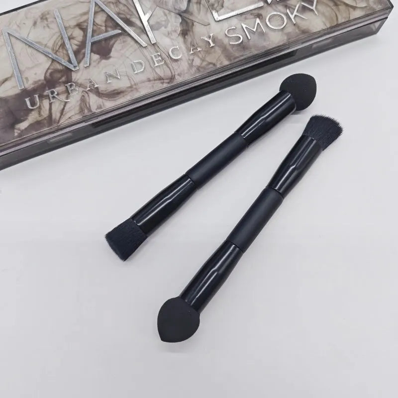 Elegant black double-headed makeup brush with a synthetic fibre brush and a miter sponge on a wooden handle.