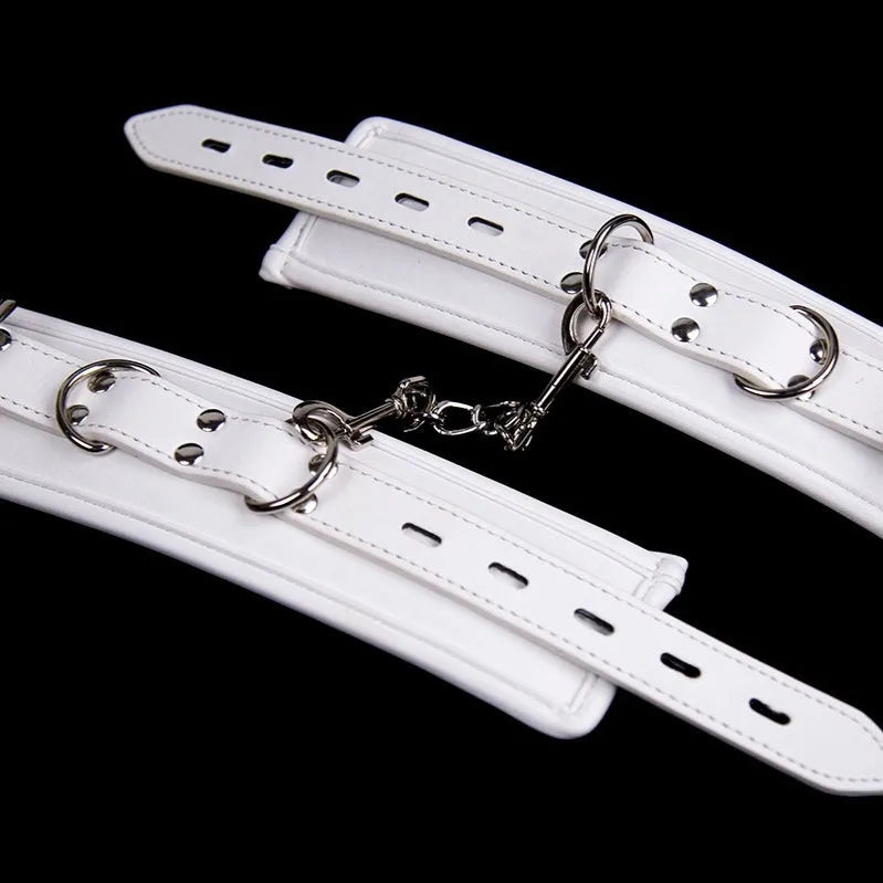 White PU sponge bondage set showing handcuffs, foot cuffs, and a neck scarf laid flat.