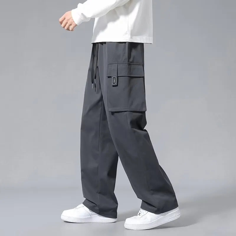 Boy wearing army green straight-leg cargo pants with large side pockets and a drawstring waist.