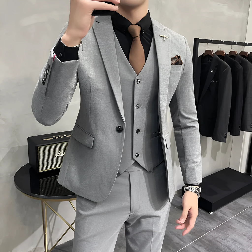 Three-piece men's acetate fibre blend business suit set in light gray with jacket, trousers, and vest.