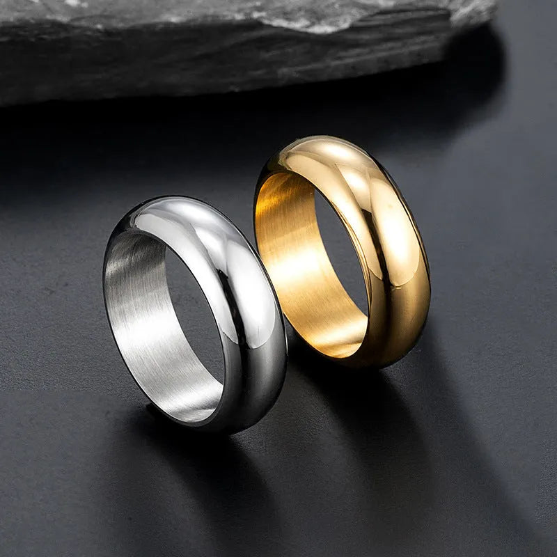 A glossy electroplated titanium steel ring in a gold colour, shown on a finger.