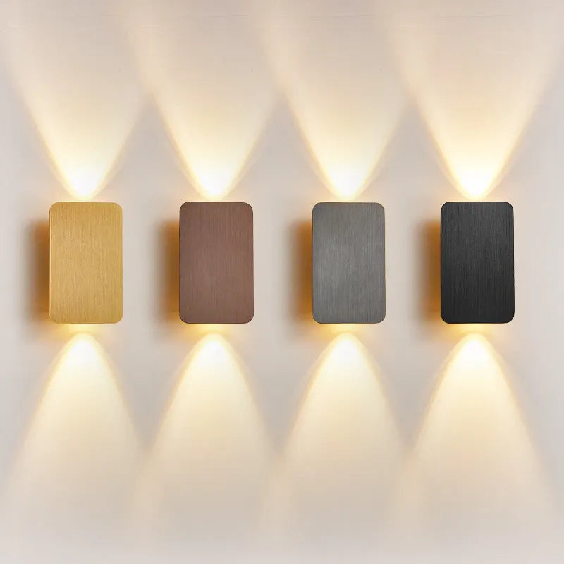 Minimalist black nordic wall lamp mounted beside a bed, emitting warm white light.