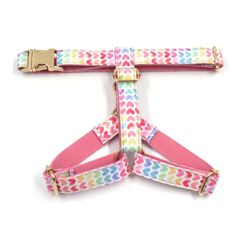 Pink colourful dog chest and back harness with gold buckle and heart-shaped stone details.