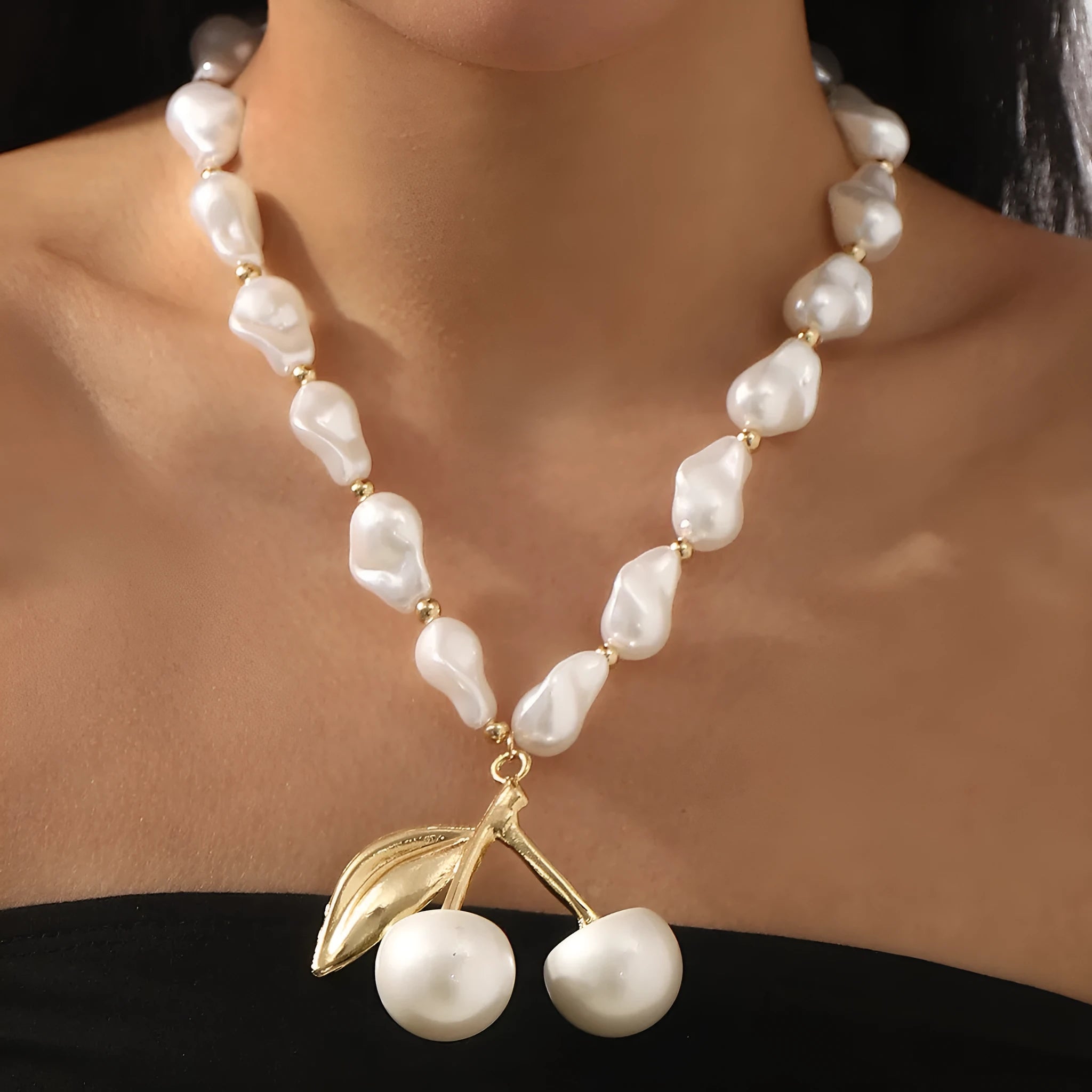 Gold tone irregular cherry and pearl necklace on a model, showing adjustable length up to 60cm.