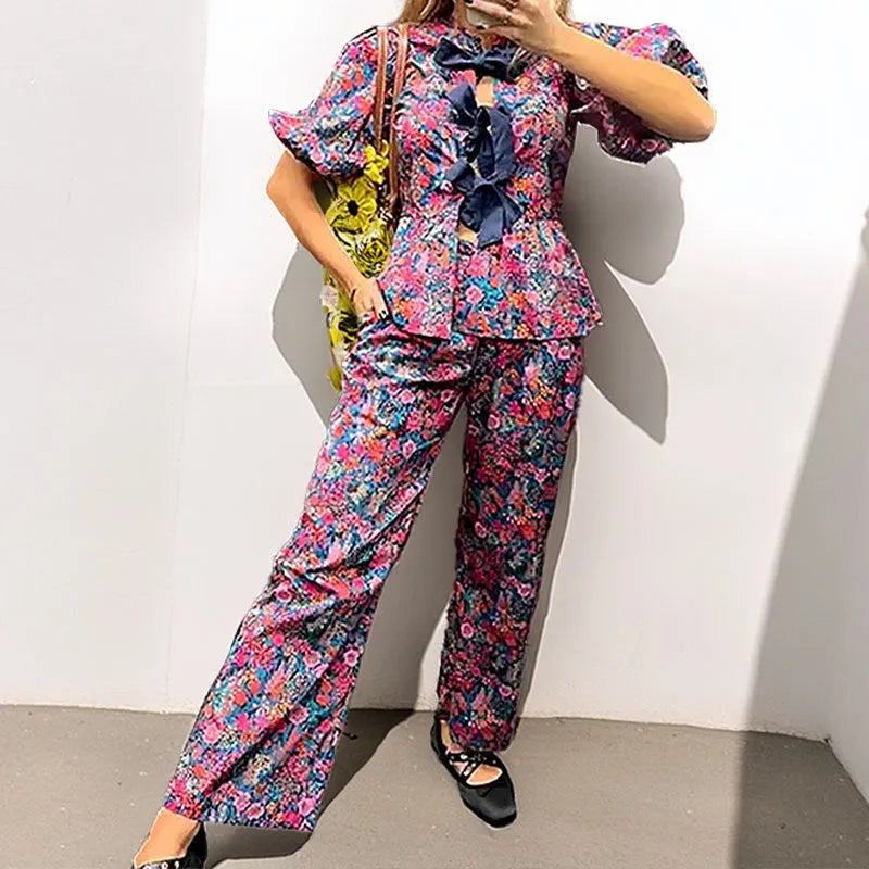 Women's floral print trouser suit with puff sleeves and tie-neck top, coordinating trousers