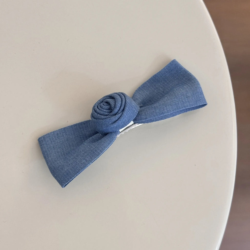 Handmade pastoral style cloth hair barrette with lace and bow decoration on a plastic hairpin.