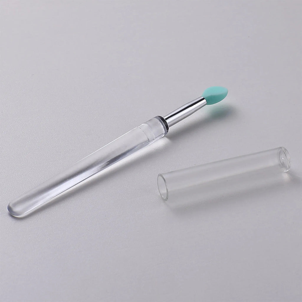 Set of reusable silicone lip brushes with protective caps in various colours on a white background.