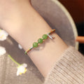 Women's diamond shape Hetian jade bracelet with woven carrying strap in light green or haze blue