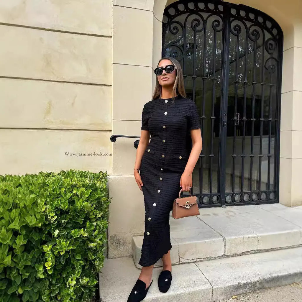 Black retro slim fit knitted long-sleeved dress with buttons on a hanger.