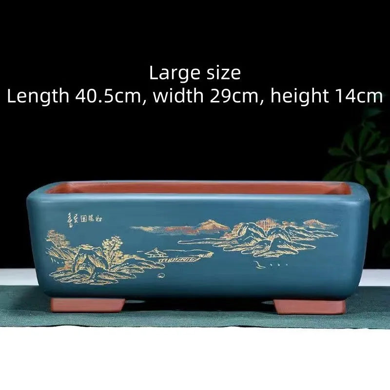 A deep blue black handmade rectangular purple clay bonsai pot on a wooden surface.