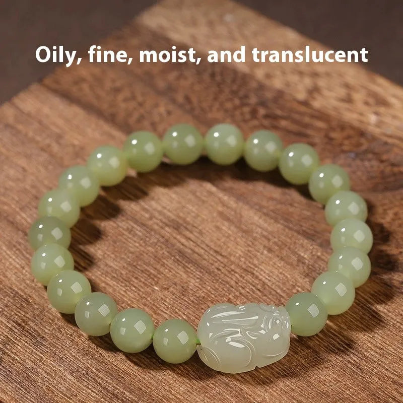 Grey Hetian jade ethnic style bracelet with polished beads on a wrist.