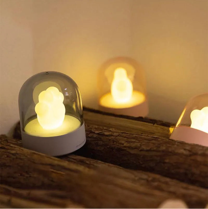 Grey cat paw shaped USB rechargeable musical night light on a wooden desk