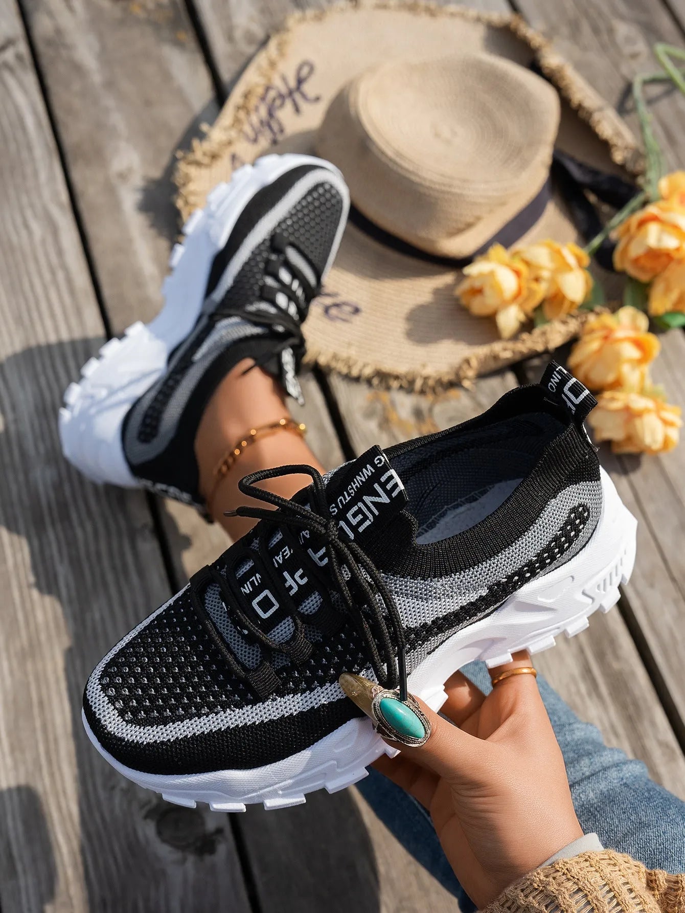 Women's Flyknit mesh lace-up sneakers in grey and white colour combination on a flat rubber sole.