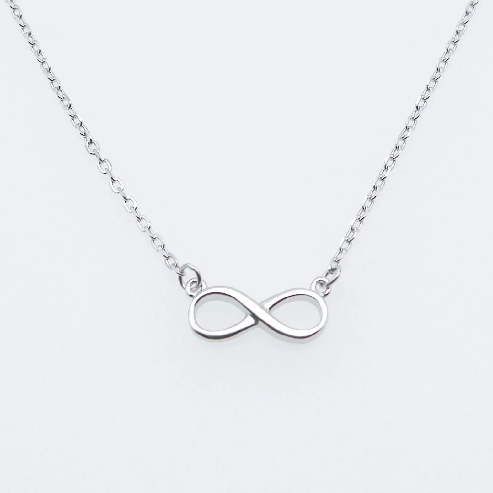925 silver through-the-body pendant necklace with adjustable chain in platinum finish on collarbone