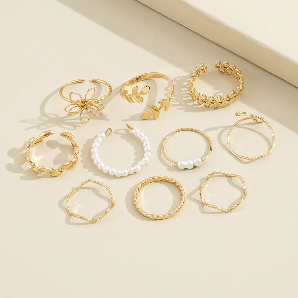 Gold openwork flower alloy ring with glossy electroplated finish on white background