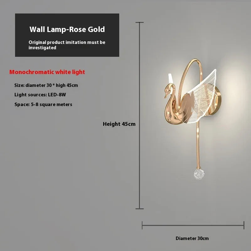 Gold modern swan-shaped bedside wall lamp with an acrylic shade mounted on a wall.