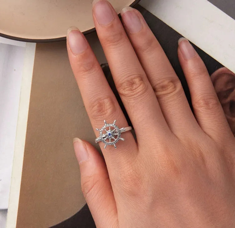 Retro women's silver ring with rotatable rudder design and inlaid zircon stone on open mouth band.