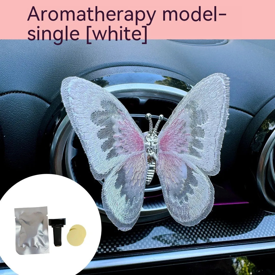 Soft fabric embroidered butterfly car air vent decoration in multiple colour options on a centre console.