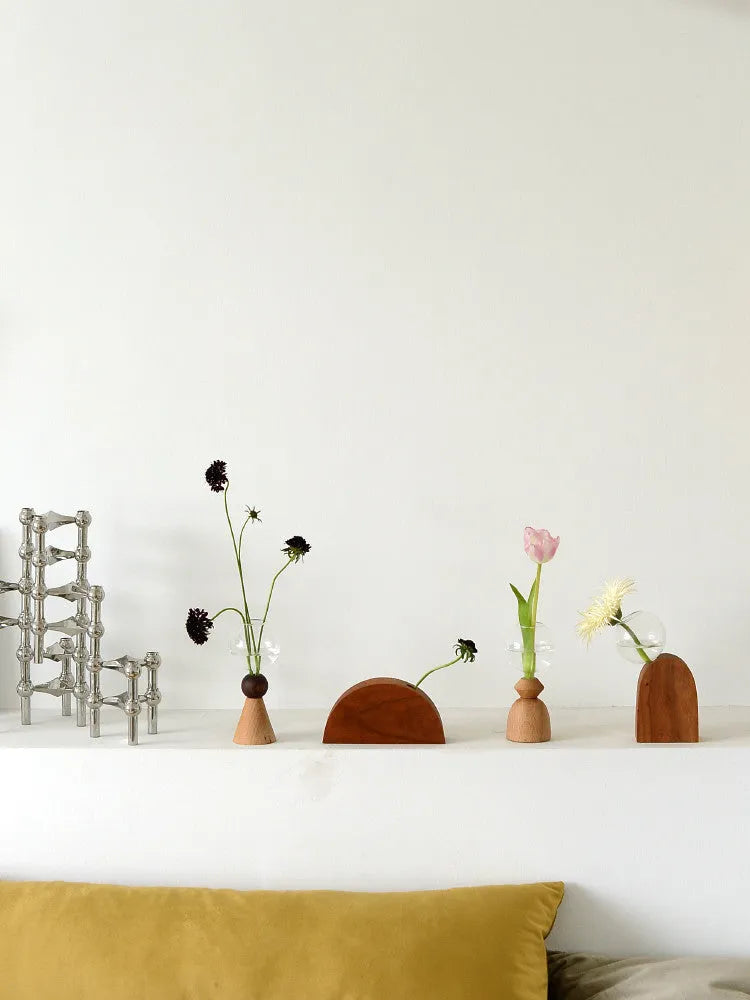 Geometric clear glass bubble vase with wooden base on tabletop with floral arrangement