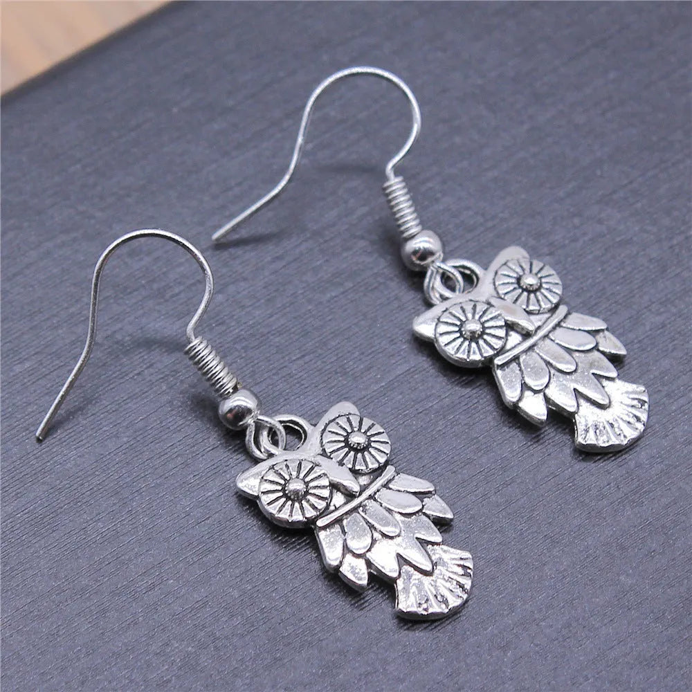 Retro minimalist handmade owl drop earrings in Antique Silver metal finish on a light background