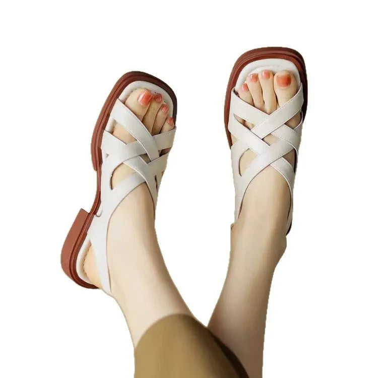 Women's glossy patent leather square toe sandals with a cross-strap design in black.