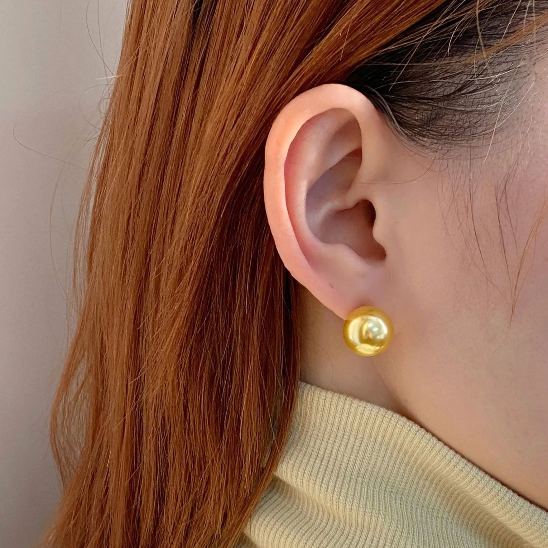 A pair of large pearl stud earrings with a geometric silver setting and an eight-pointed star detail on a white background.