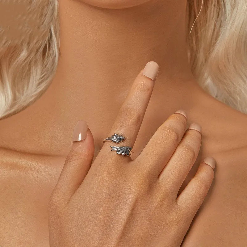 Unisex silver adjustable open ring with flying dragon wing motif on neutral background