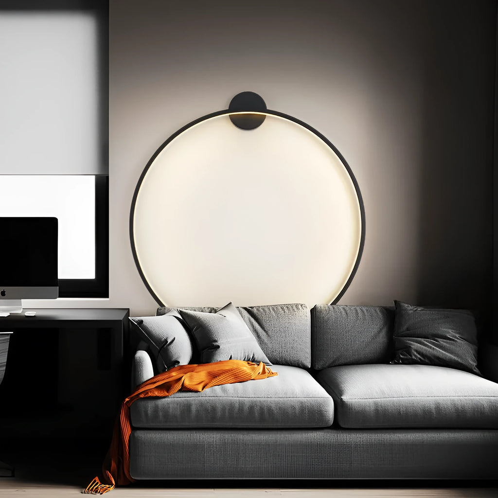 Minimalist black ring wall lamp with acrylic shade mounted on a bedroom wall
