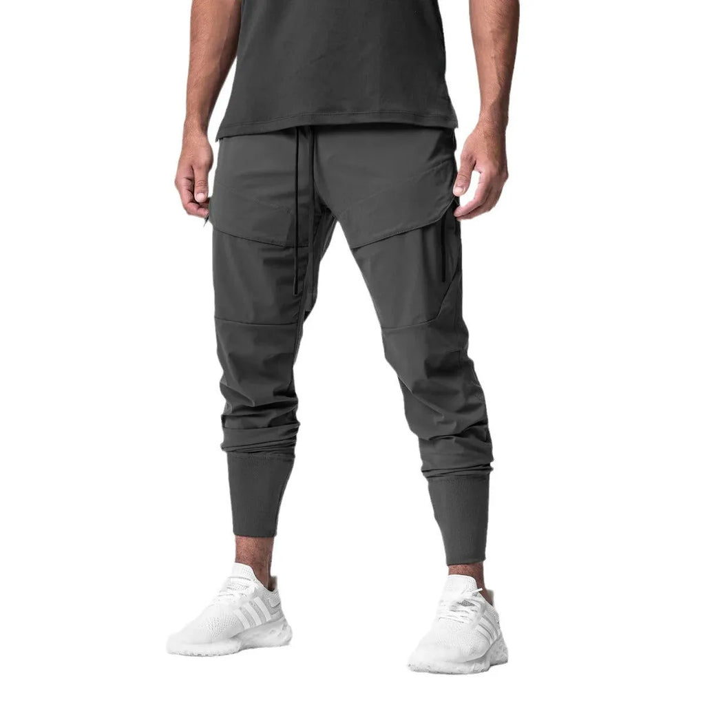 Men's solid colour polyester jogger pants in black, mid-waist micro-elasticity sports trousers for autumn leisure.