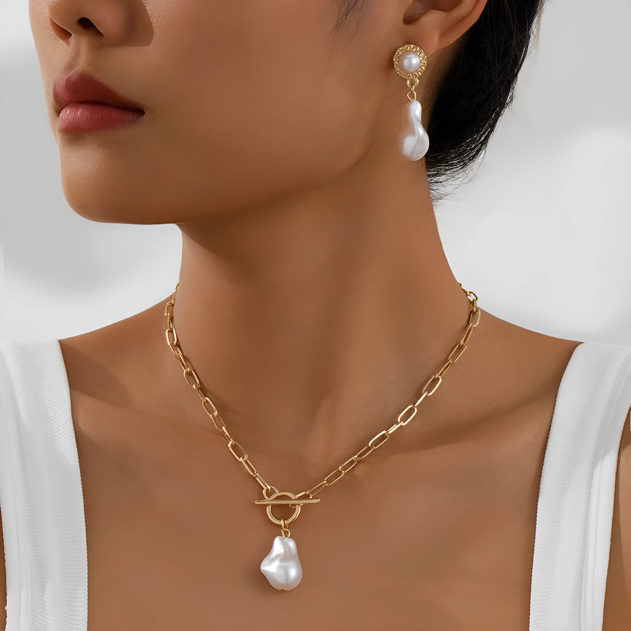 Gold-tone retro baroque necklace and earring set with a pearl pendant on an iron chain.