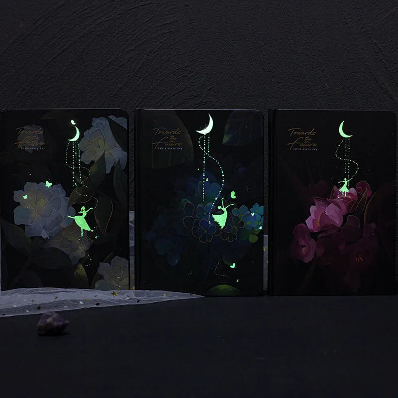 A5 hardback notebook with luminous cover open to show colour illustrated pages.