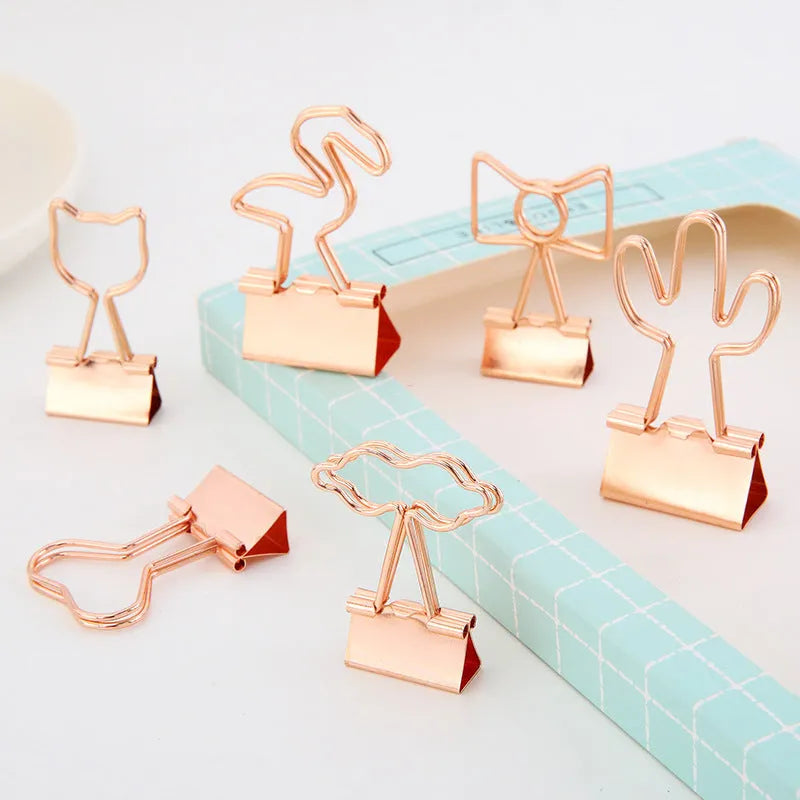 Gold-coloured long tail metal clip with a choice of flamingo, love, clouds, cat, cactus, or bow decorative design.