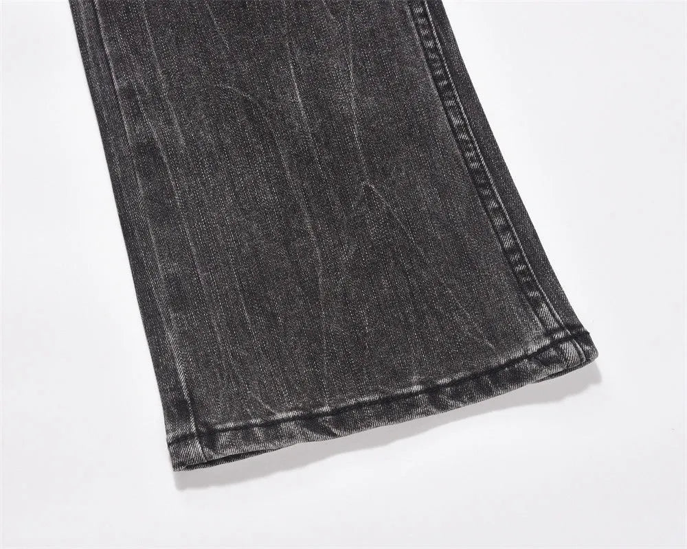 Men's black washed denim jeans on a flat surface showing full leg and pocket details