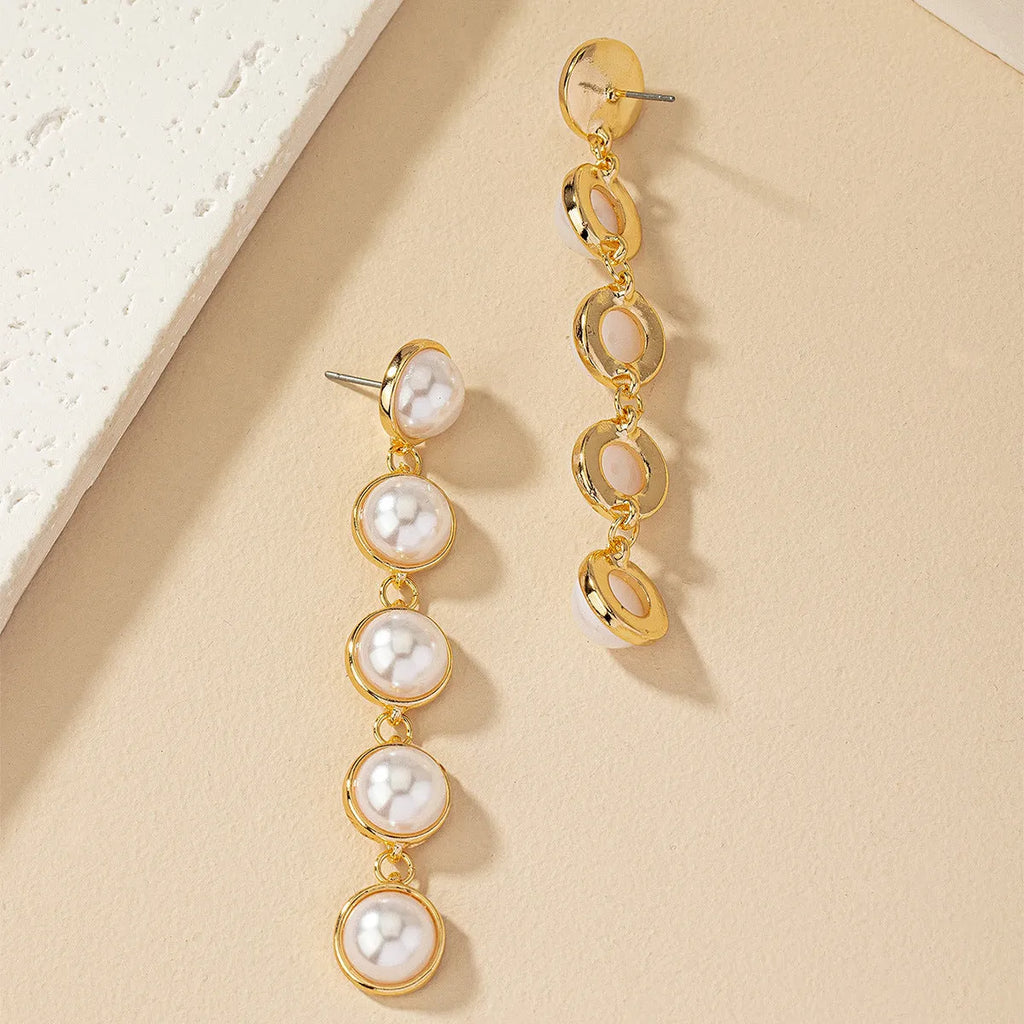 White long pearl tassel drop earrings made of electroplated metal with water flow design on white background