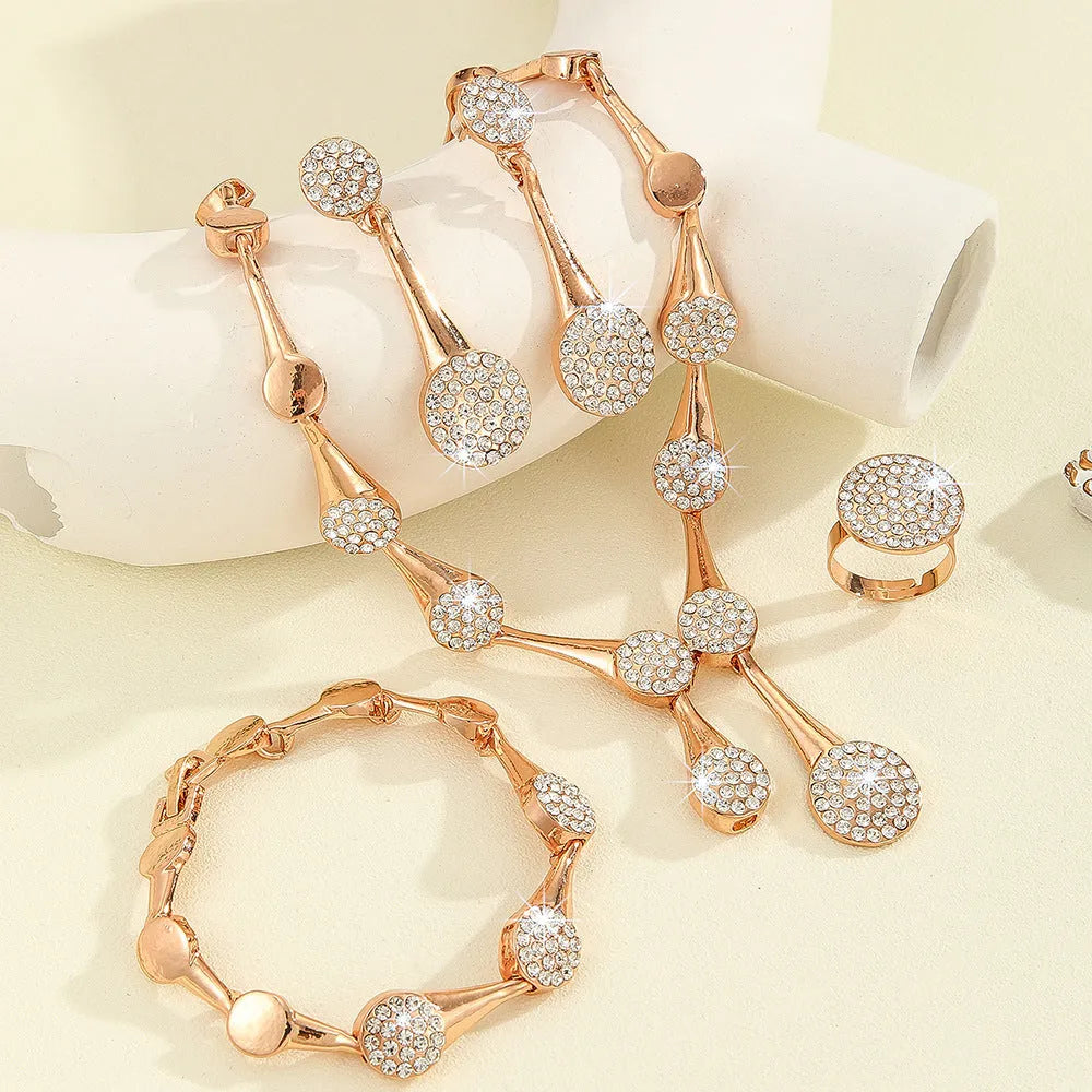 Gold alloy necklace earrings and bracelet set with bow and fan motifs on a light background