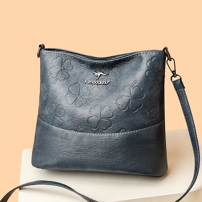 Soft PU leather bucket bag with embossed flower pattern and stitching details in black