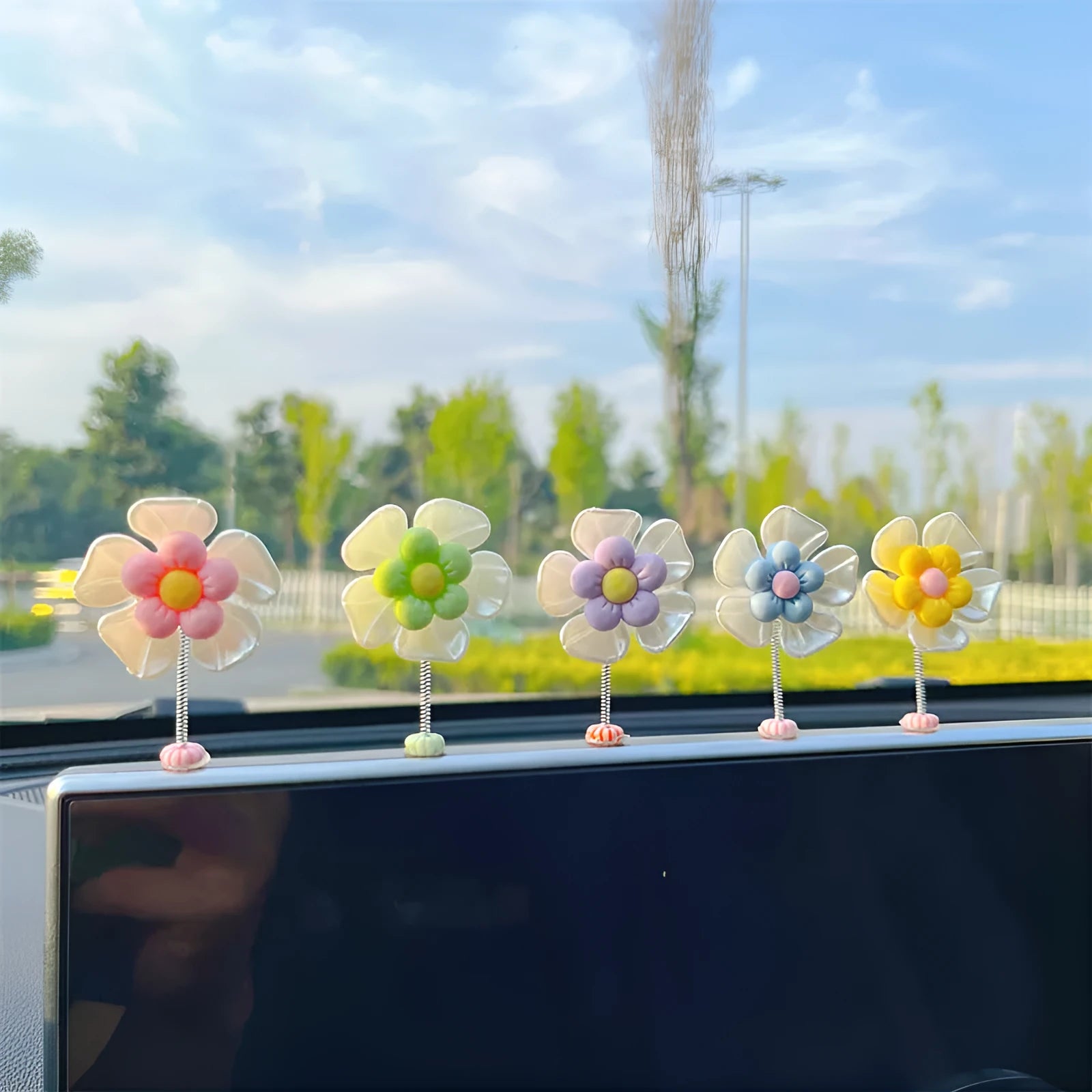 Small blue plastic swing ornament for car dashboard, 5cm tall on a grey surface.