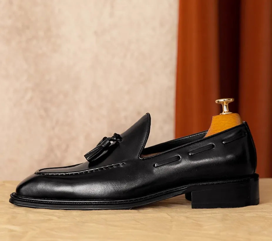 Men's black genuine leather loafers with a fringed detail and slip-on design.