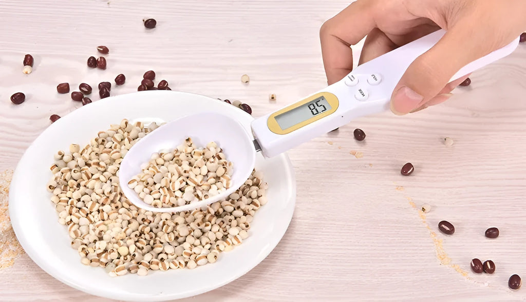 Black electronic measuring spoon scale on a kitchen counter showing digital display.