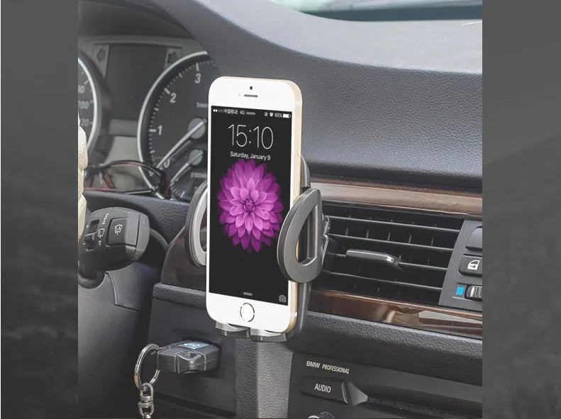 Black plastic car phone holder mounted on air conditioning outlet holding smartphone